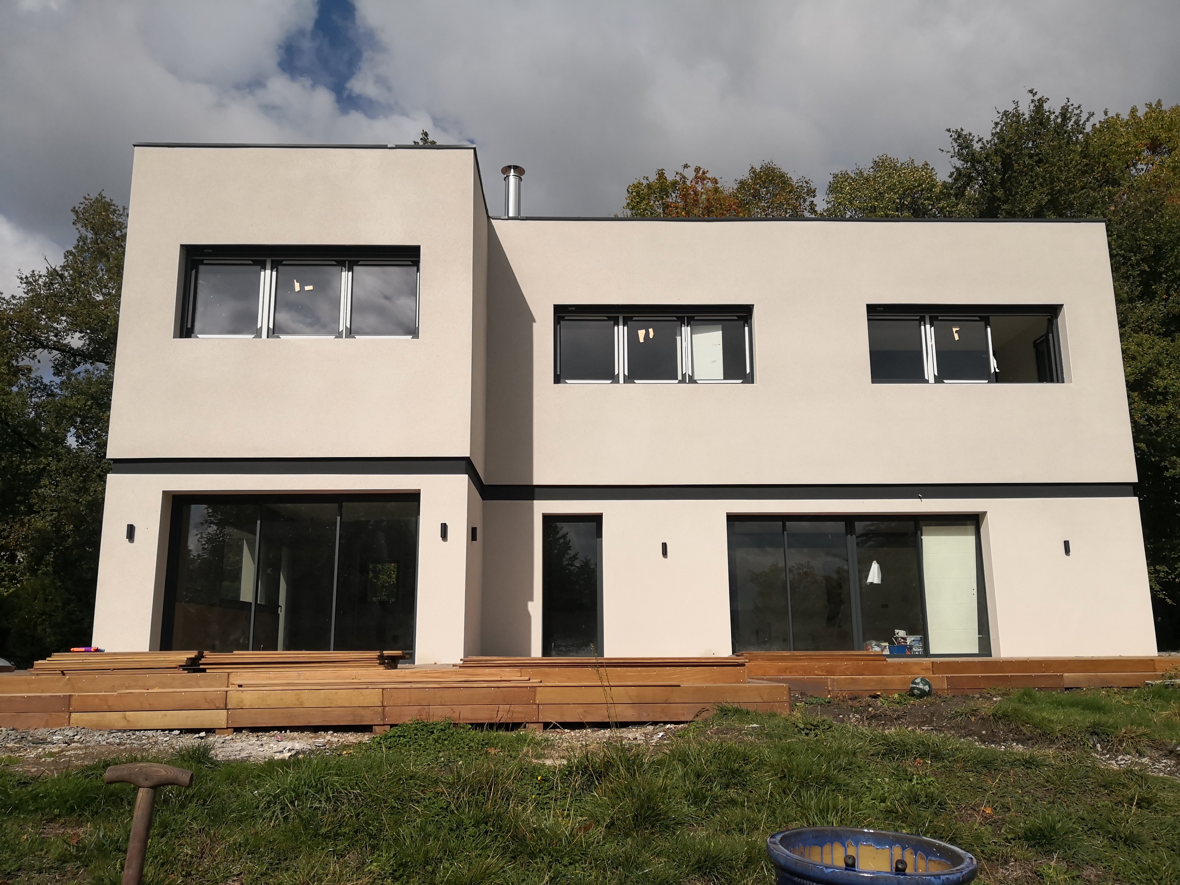 Maison cubique enduite avec terrasse bois
